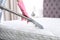Woman disinfecting mattress with vacuum cleaner, closeup.