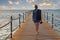 Woman with dive mask and snorkel on wooden pier extending into the sea