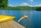 Woman diving off the dock into lake on a hot summer day