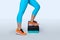 Woman do exercise on a black-turquoise fitness step