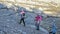 Woman do Nordic walking in nature near mountain river. Girls and children use trekking sticks and nordic poles