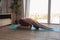 Woman do youga or pilates exercise at home. She is in sportswear and using mat. Slim flexible and fit brunette caucasian woman.