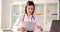 Woman doctor examines medical documents and looks into laptop