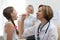 Woman doctor examining little girl mouth at office. Doctor at hospital checking the sore throat of a young patient