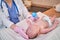 Woman doctor feeding a newborn baby from a bottle. Nurse gives water to the child