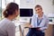 Woman Doctor Or GP In Office Meeting Teenage Female Patient For Appointment