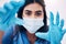 Woman, doctor and hands with face mask for healthcare, exam or busy with surgery at the hospital. Female medical expert