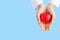 Woman doctor hands holding red heart on wide blue background donate for foundation hospital blood care concept Panoramic world