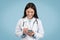 Woman doctor happily using smartphone, digital health