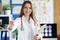 Woman doctor holding clipboard with documents and giving hand for handshake