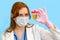 Woman doctor holds a urine test on a blue background, close-up