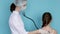 Woman doctor listening to breathe of child girl with phonendoscope