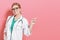 Woman doctor on pink background points something