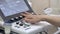 Woman doctor is pressing buttons of apparatus for medical ultrasound, closeup of hand