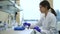 Woman doctor scientist inserting bottles dna rest tubes in panel Spbd. female chemist preparing