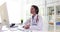 Woman doctor sits at desk and conducts video conference