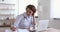 Woman doctor wearing white coat using laptop writing notes