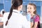 Woman doctor in white coat examining throat