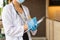 Woman doctor in white coat with stethoscope and blue glove write report by pencil in a notebook in the hospital.