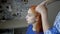 A woman does her hair and braids on the head of a thoughtful red-haired girl. Concept. Portrait of a woman. Side view