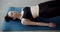 A woman does muscle exercises on the fitness mat in a physiotherapy studio.