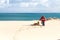 A woman and dog on a beach take pictures with smartphone. With copyspace