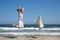 Woman and dog breed Labrador jumping on the beach