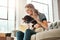 Woman, dog and calm smile on sofa in living room for animal care, love and support in home. Young female, pet care and