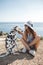 Woman with a dog dalmatian. Girl and her friend dog on the blue sea background