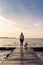 Woman with dog enjoy sunrise at lake, backpacker