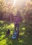 Woman and dog mowing lawn in garden