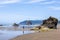 Woman with a dog and other people are walking on the water in the North-West of the Pacific coast with fancy rocks sticking out of