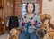 Woman with dog is sitting in armchair and knits.