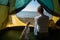 A woman and a dog are sitting in a tourist tent by the sea. Recreation in nature.