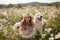 Woman dogs meadow chamomile. Woman embraces her furry friends in a serene chamomile field, surrounded by lush greenery