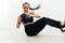 Woman doing abdomen exercises sitting indoors holding a medicine ball