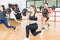 Woman Doing Barbell Lunges With Friends In Health Club