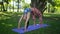 Woman doing bridge pose in park