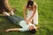 Woman doing cardiac massage to unconscious person with heart attack on green lawn