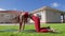 Woman doing cat-camel stretch in her backyard