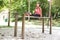 Woman doing dips exercise on balancing bar in park