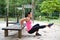 Woman doing dips on right leg in outdoor exercise park