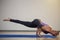 Woman doing eka pada koundinyasana on exercise mat