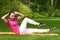 Woman doing exercise on press keeping equilibrium with upper part of the body and legs in air.