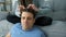 Woman is doing french braid on short men's hair, closeup head view.