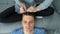 Woman is doing french braid on short men's hair, closeup head view.