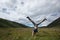 Woman doing a handstand on mountain meadow