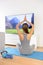 Woman doing home yoga meditation in front of TV