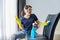 Woman doing house cleaning, female in headphones and gloves with detergent