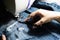 Woman doing jeans patchwork using sewing machine